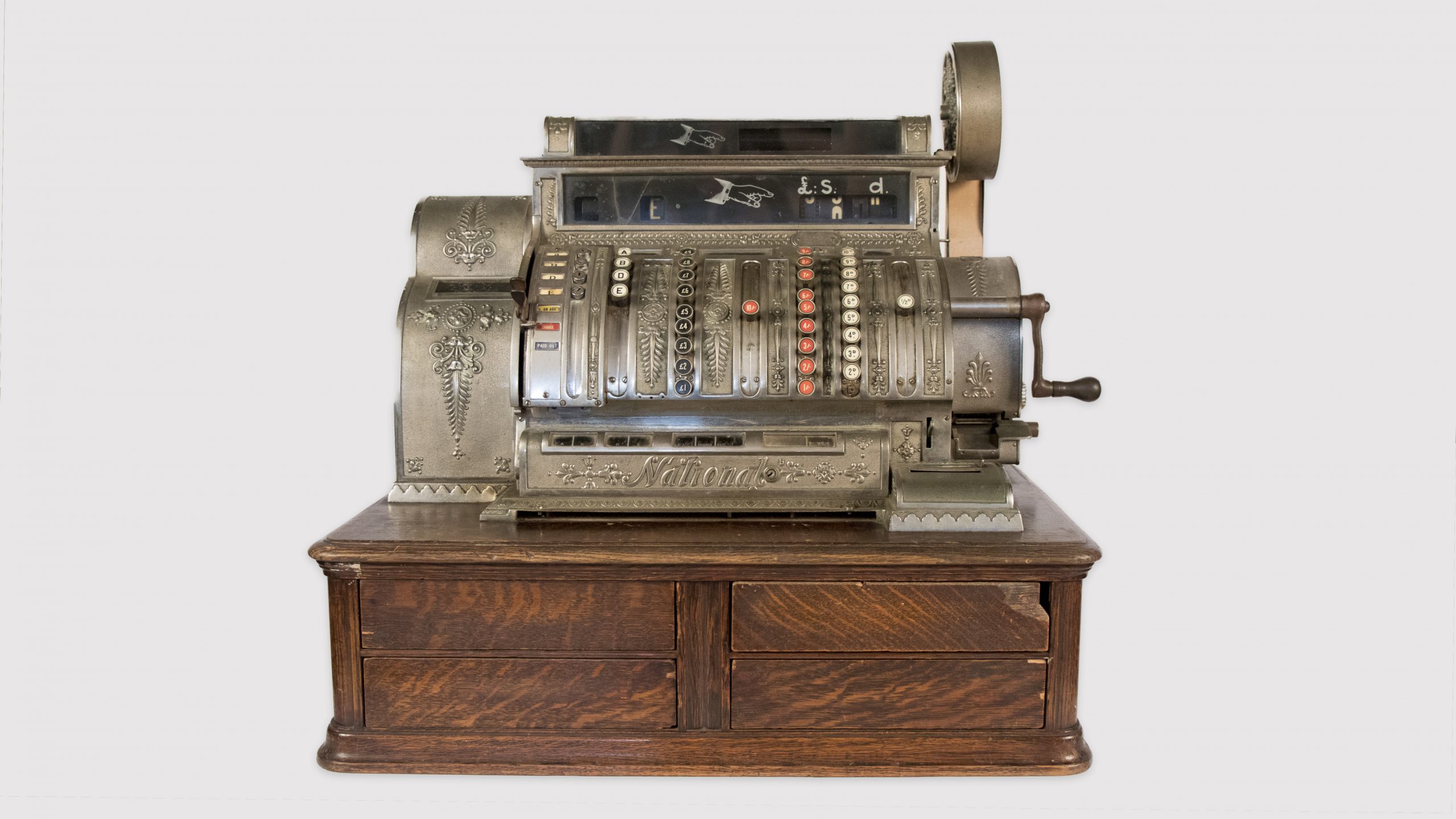 metal antique cash register on wooden drawers