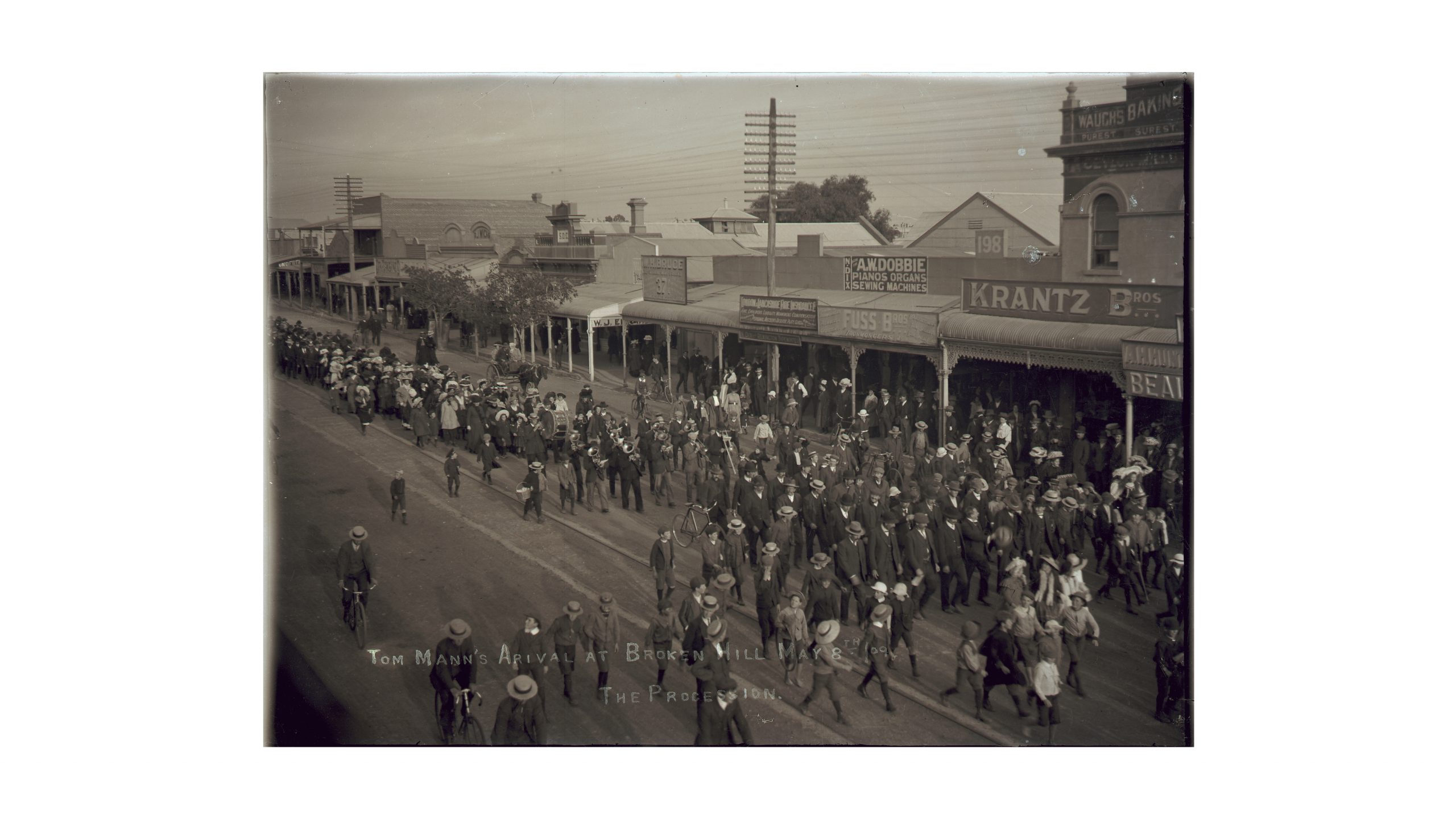 black and white photograph of a crowd on the main street of a country town