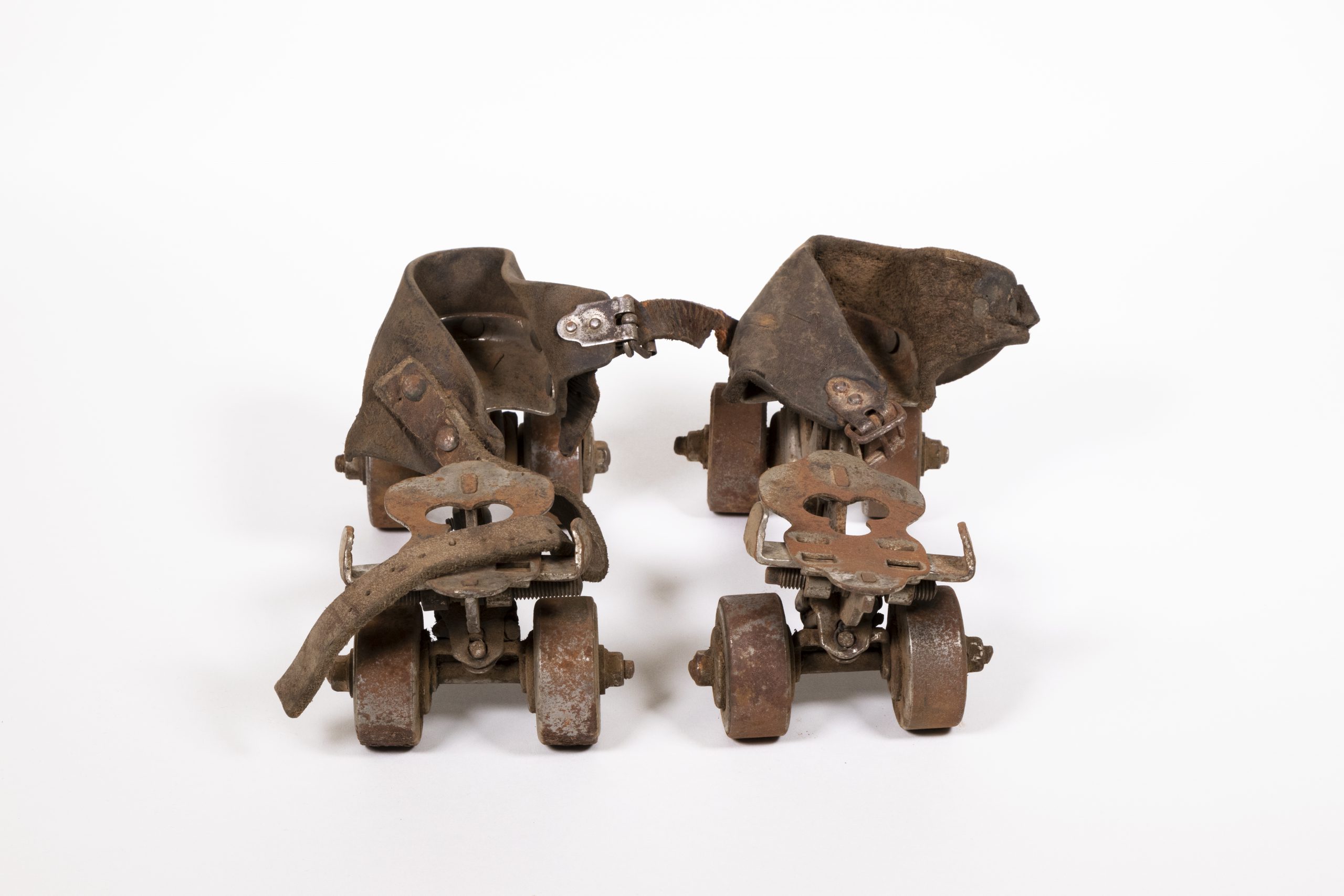 antique roller skates, they look like four-wheeled, metal contraptions with leather ankle straps