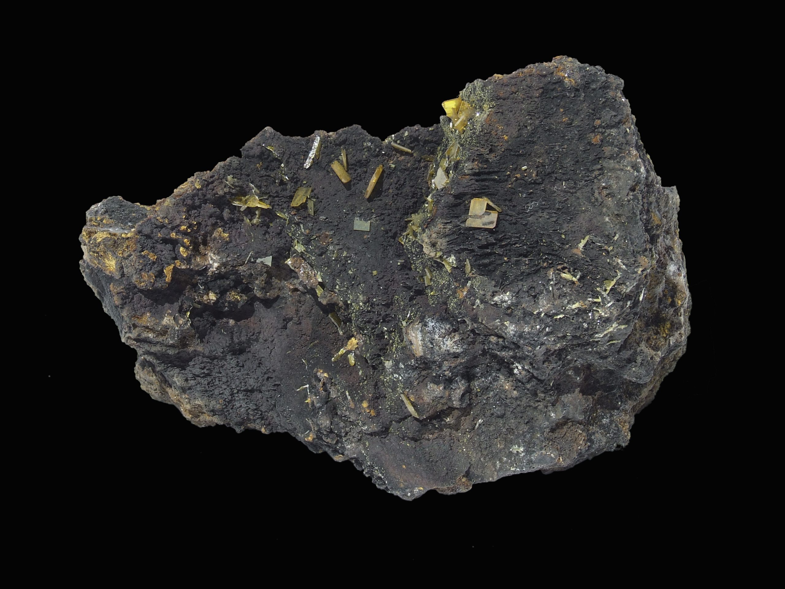 gray/black rock with yellow gemstones poking out in various places