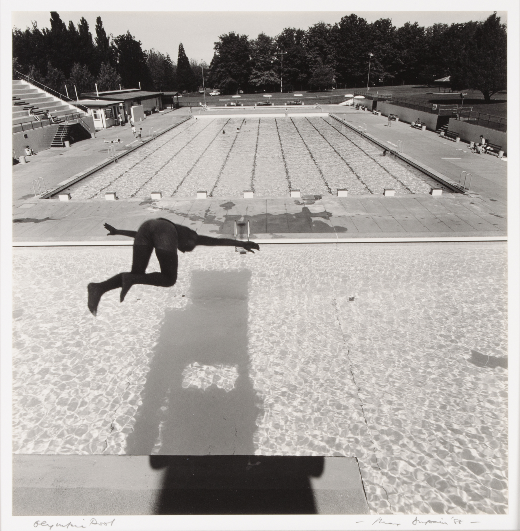 black and white photograph of somone platform diving into a pool from above