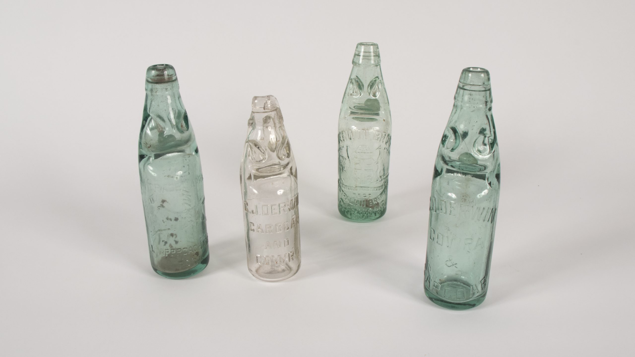 four glass bottles with beads held inside the sculpted neck