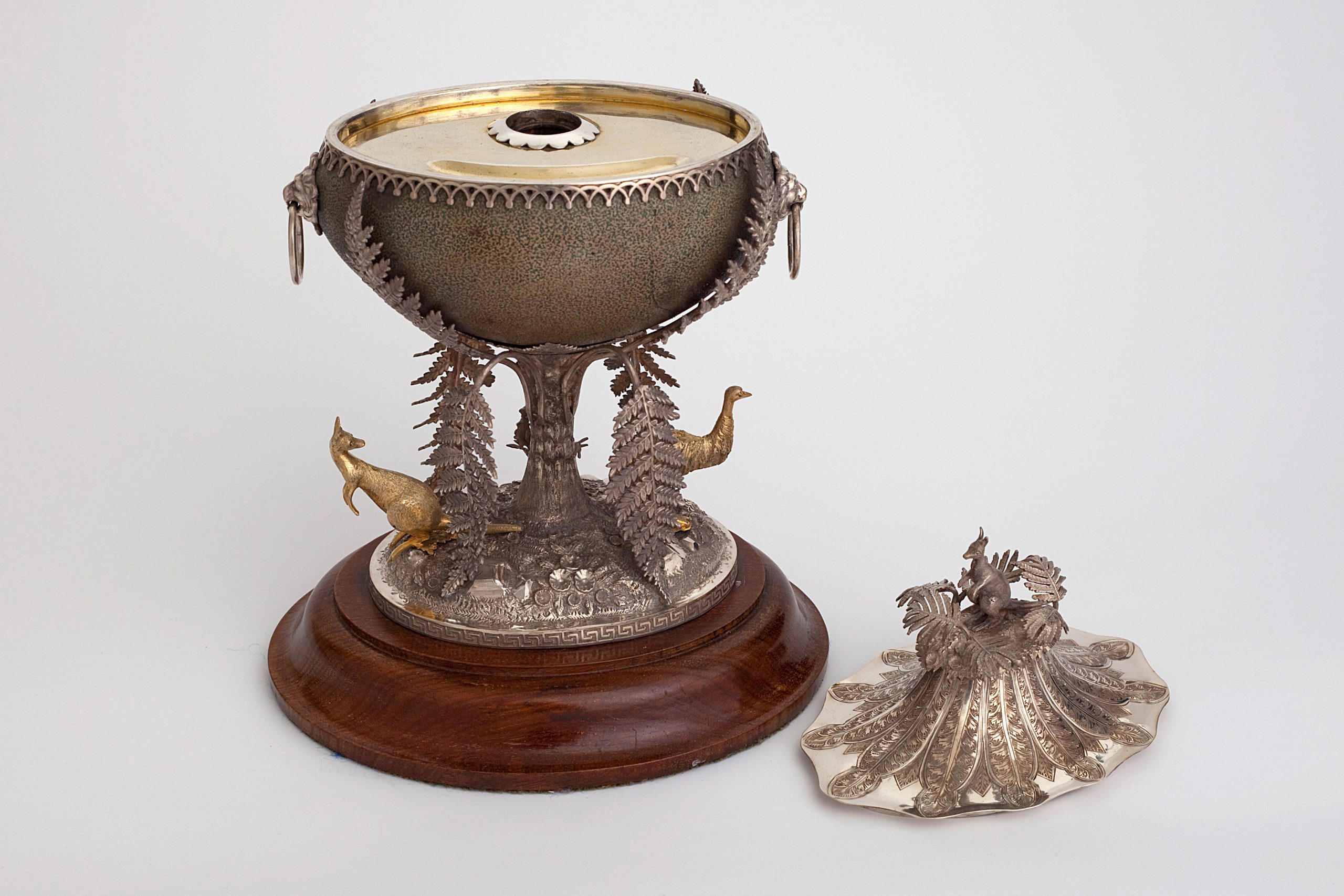 ornate ink well with lid removed revealing a gold interior with a small circular opening