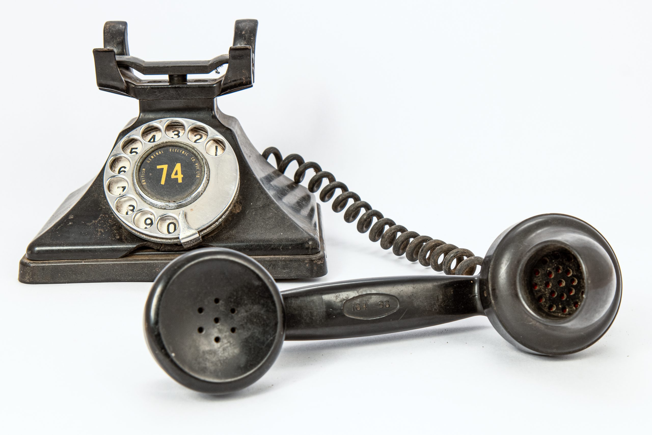 black rotary telephone with a spiral-corded earpiece