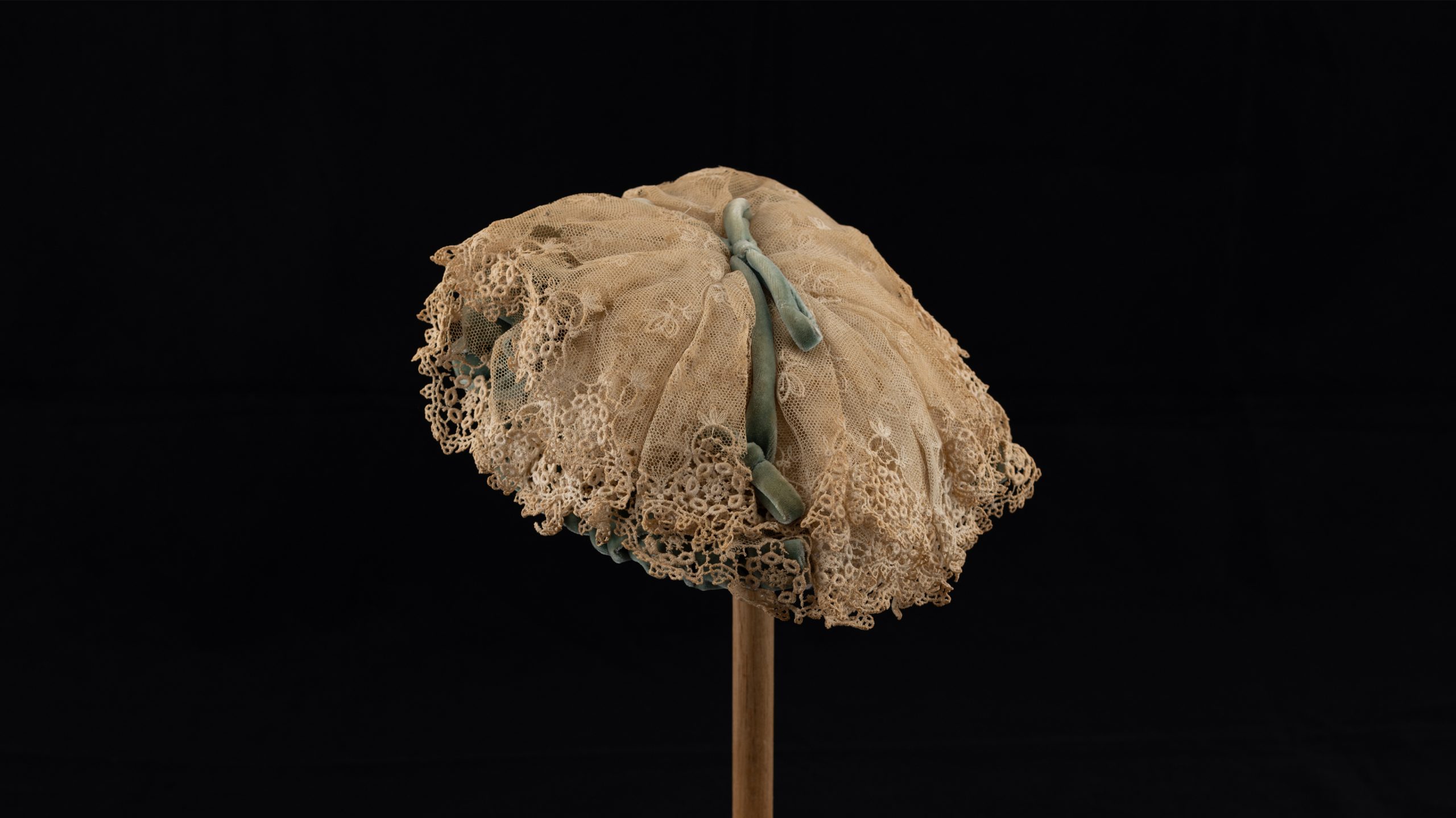 lace baby bonnet on wooden stand