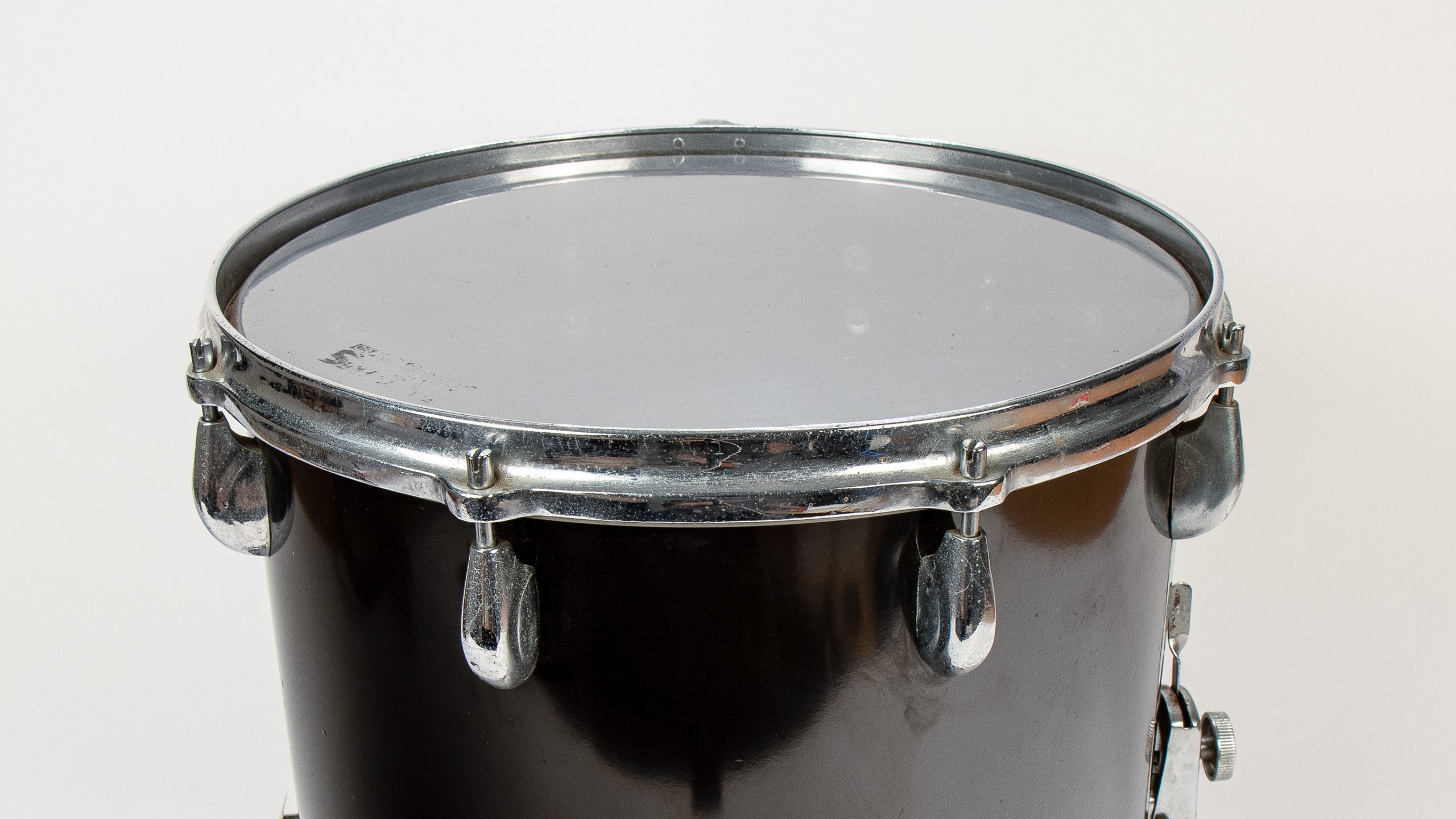 Silver, reflective top of a black drum with silver fittings.