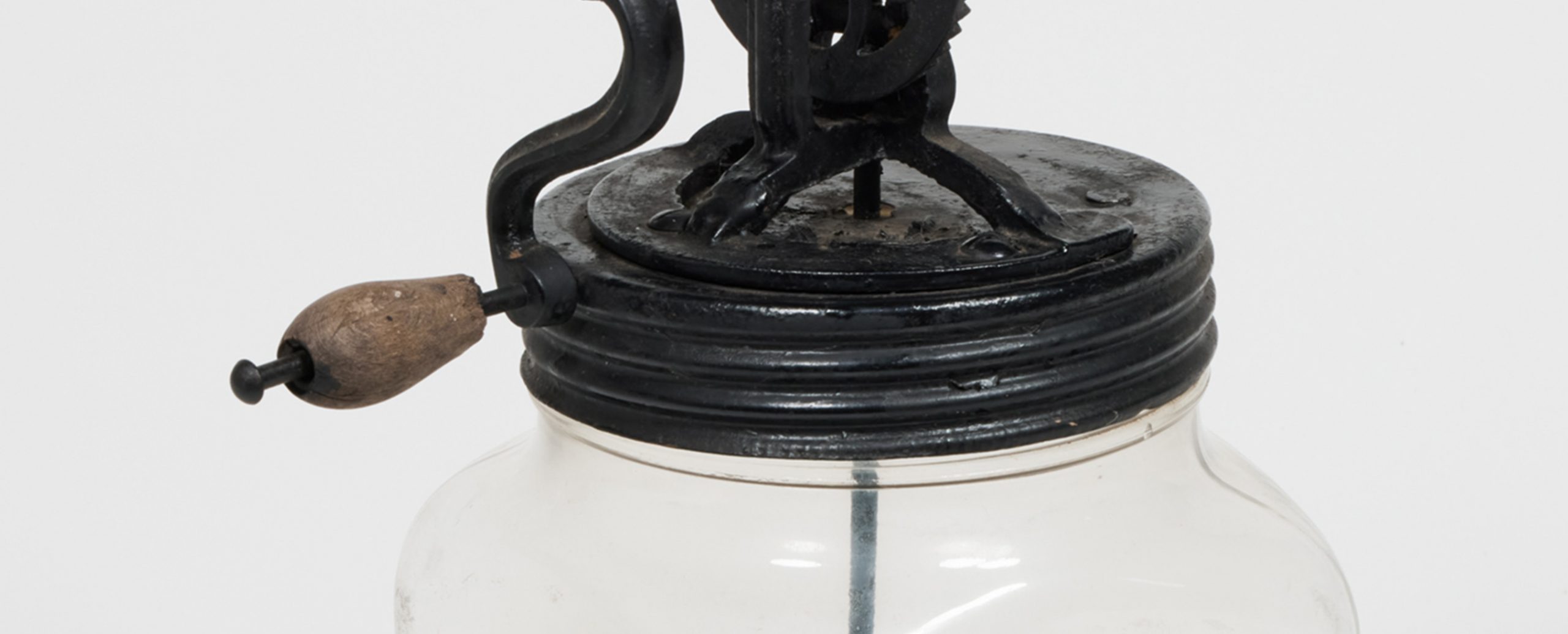 Close up of device which looks like a manual egg beater secured through the lid of a glass jar