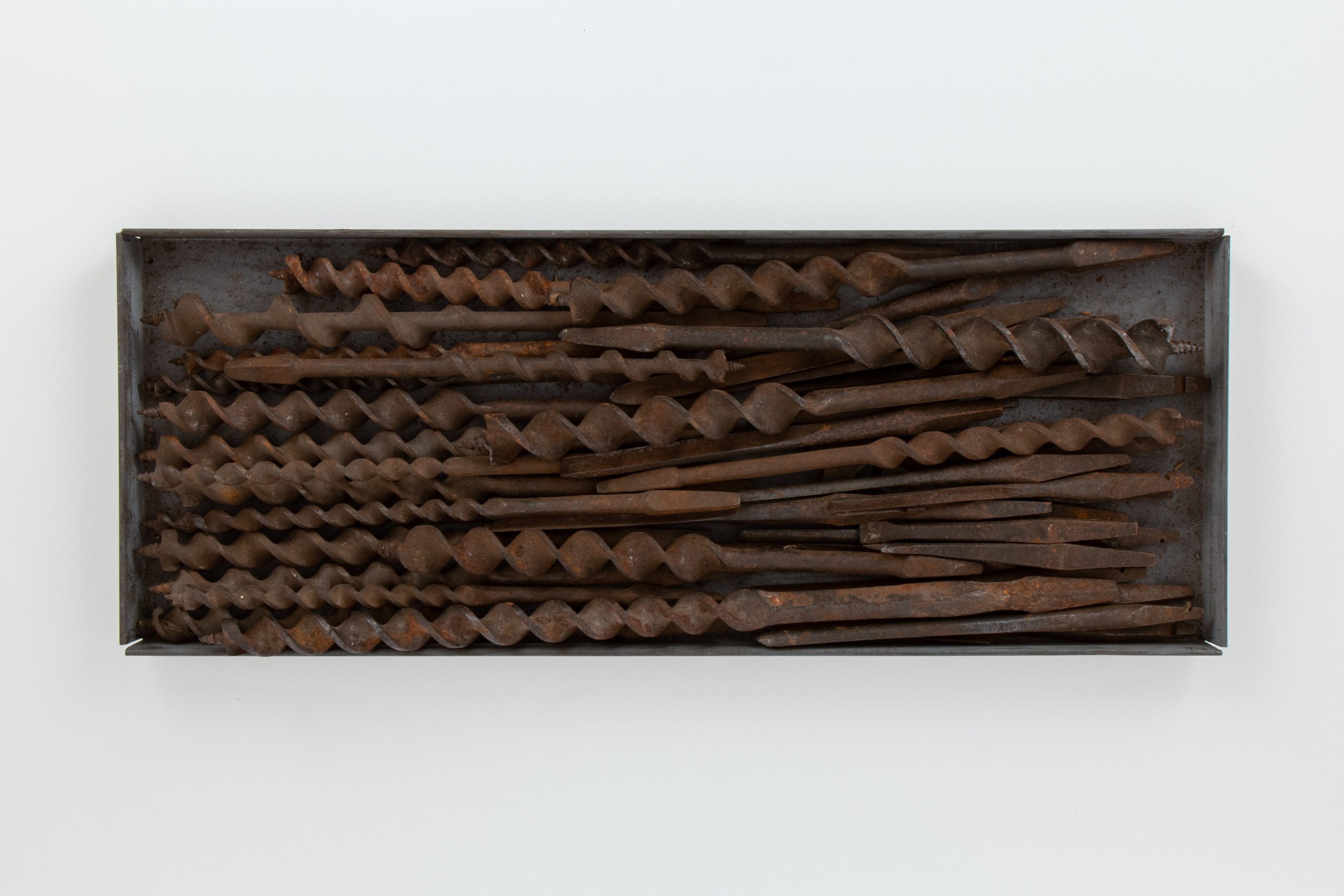 Rectangular tray of rusty, assorted drill bits.